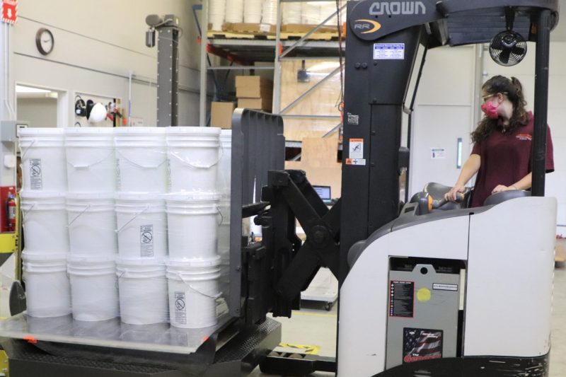 Image 1. Mary building a unit load of pails.