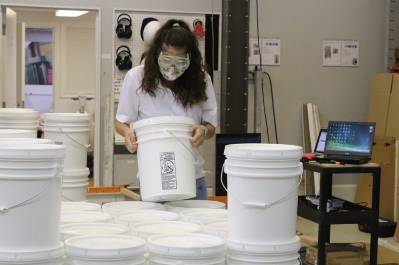 Image 5. Mary Paz Alvarez building a unit load of plastic pails.