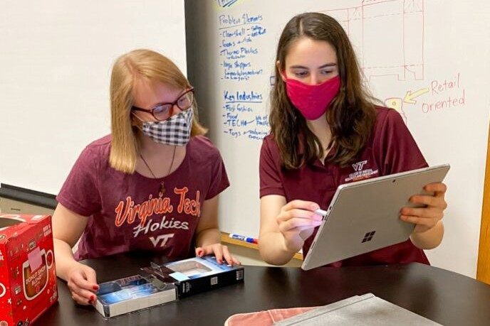 Image 1. Rosa Williams and Julia Barbosa making initial notes about different e-commerce packages.