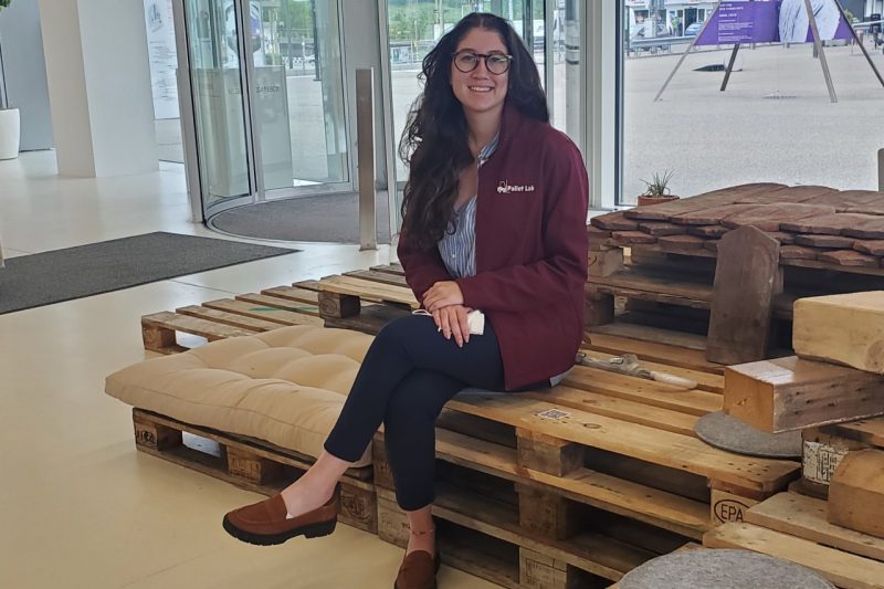 Image 2. Mary Paz Alvarez posing on an art installation and seating area made from used pallets.