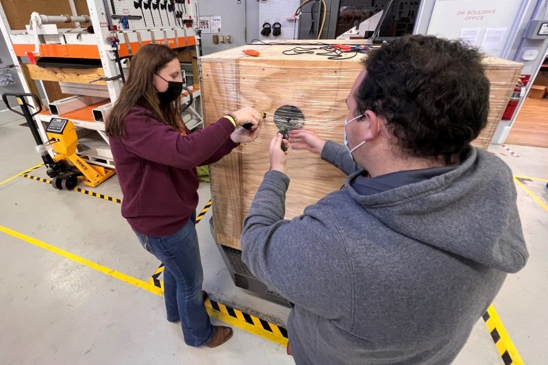 Image 1. Gabby Brophy (Junior) and Michael Harris (Junior) are measuring the containment force of a unit load Image 1. Highlight Brands Synergy 4 High Profile Wrapping Machine.