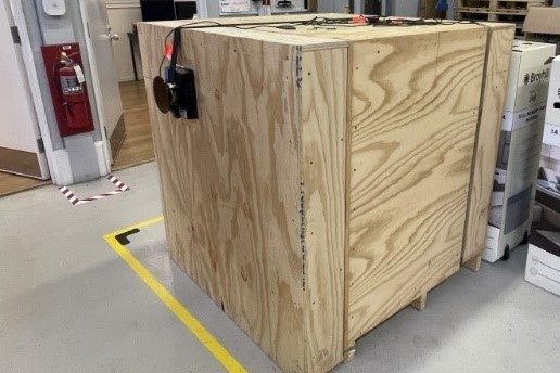 Image 2. Rigid test unit load with a length and width of 48 inches and a height of 50 ¼ inches constructed of plywood and lumber. Shows load cell located on side of unit load. Image 3. Rigid test unit load with a length and width of 48 inches and a height of 50 ¼ inches constructed of plywood and lumber. Shows load cell located on side of unit load.
