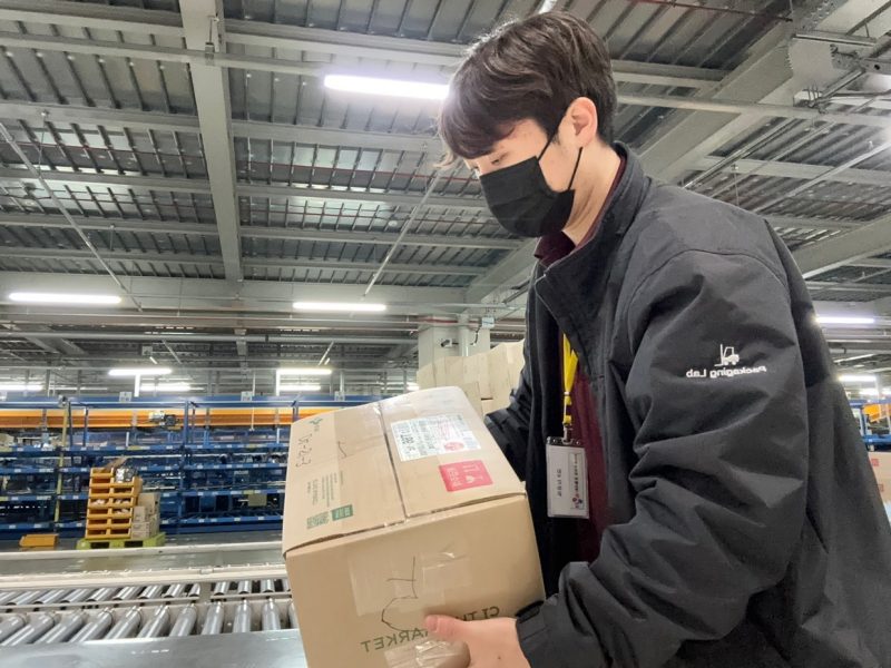 Image 1b. Kim placing decoy box into the supply chain.